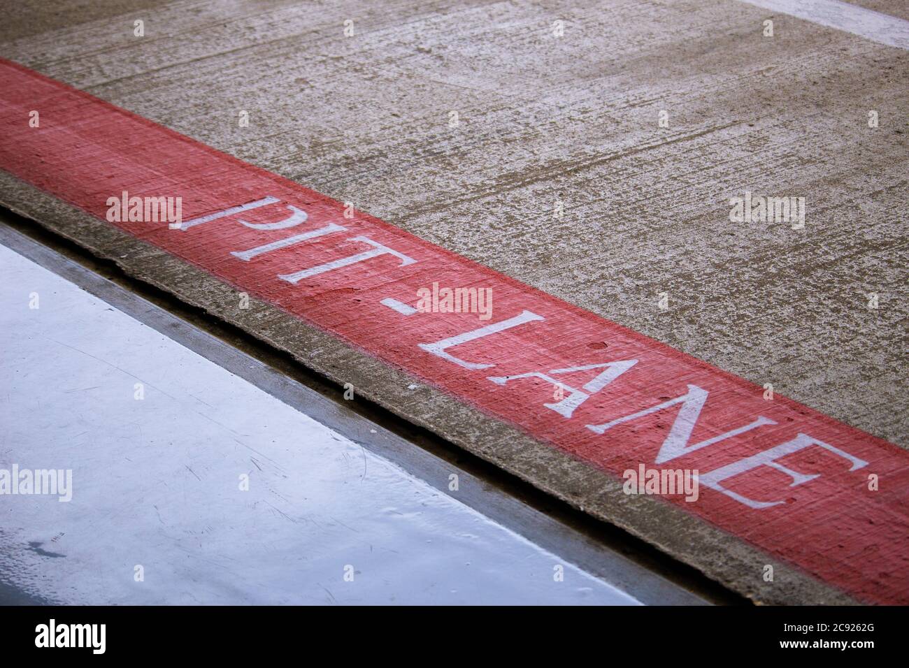 Pit Lane scritto in lettere bianche sul marciapiede al circuito di Silverstone, Regno Unito Nessun popolo Foto Stock