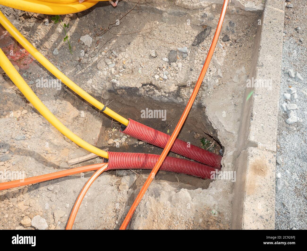 Lavori stradali per l'installazione di cavi in fibra ottica per  telecomunicazioni. Tubo di sicurezza con cavi. Trench per linee ottiche  telefoniche sotterranee Foto stock - Alamy