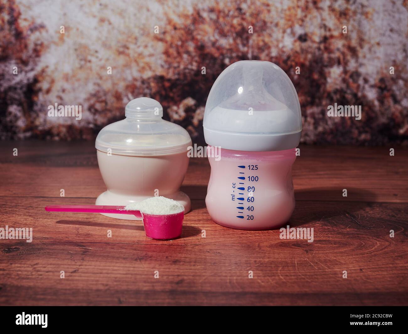 Una bottiglia di latte biologico per neonati, su fondo marrone Foto Stock