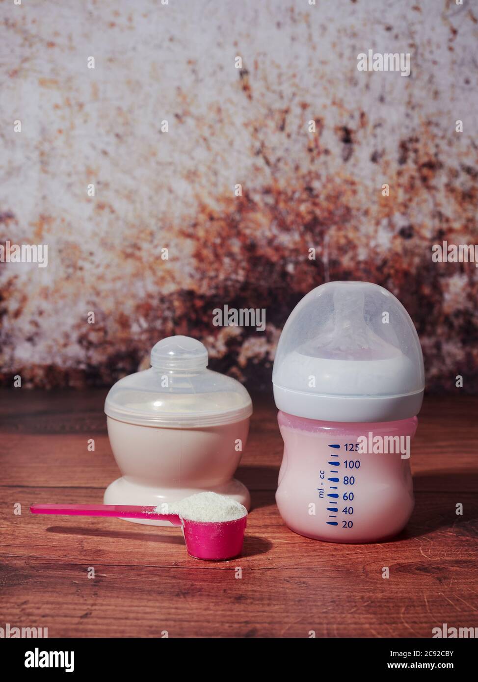 Una bottiglia di latte biologico per neonati, su fondo marrone Foto Stock