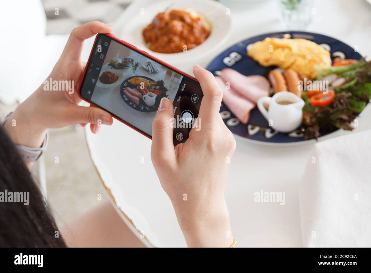 12 luglio 2020 - Khaoyai Thailandia : mani con il telefono primo piano immagini della colazione. Foto Stock