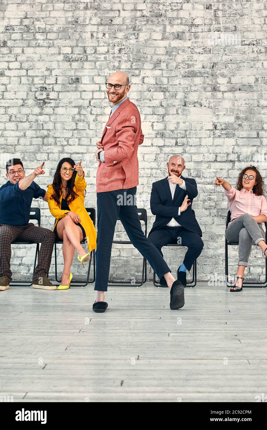 felice uomo lamentando sofferenza cyber bullismo dai suoi compagni. outcast in ufficio Foto Stock