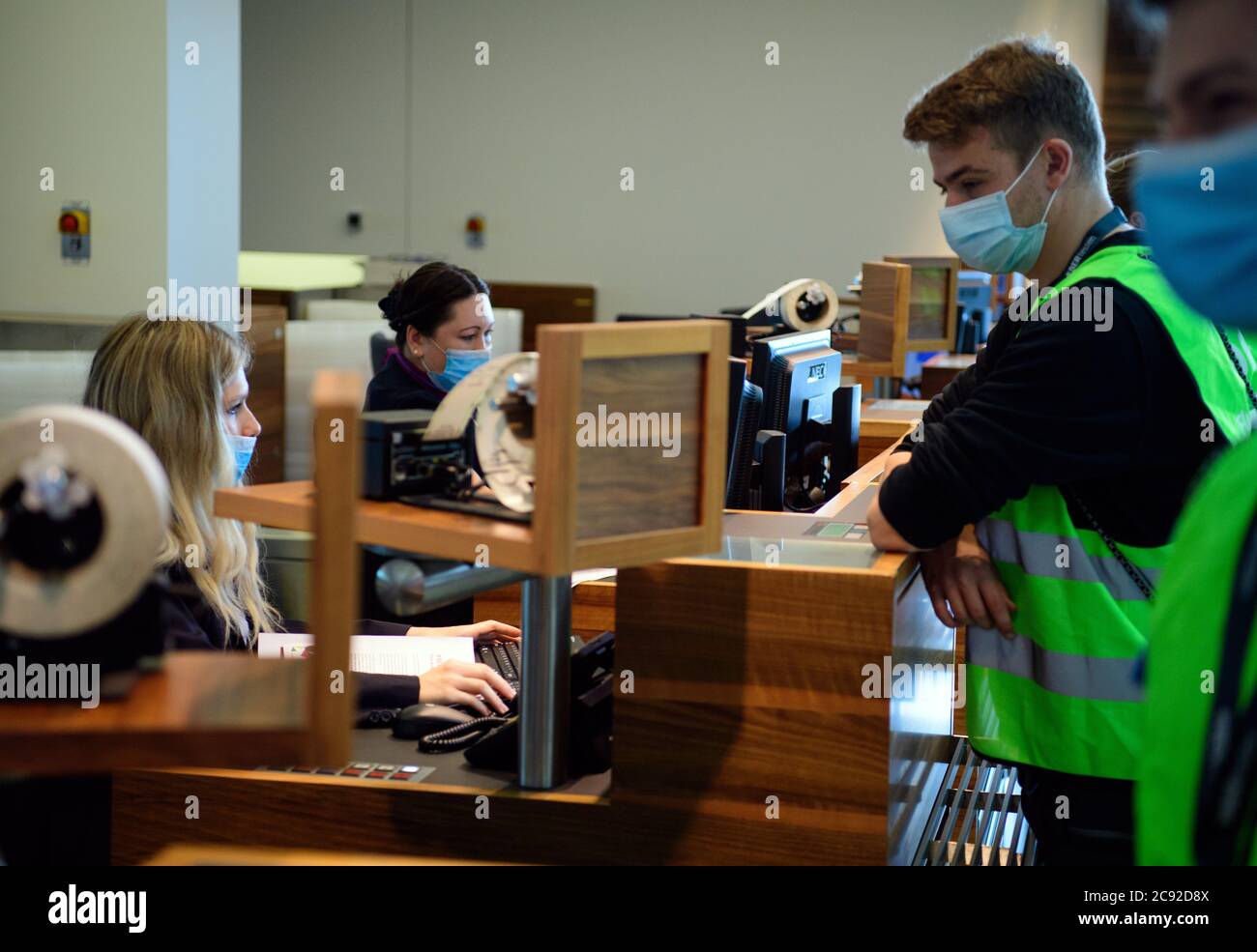 28 luglio 2020, Brandeburgo, Schönefeld: Gli extra in giubbotti verdi ad alta visibilità saranno esposti al banco del check-in del Terminal 1 dell'aeroporto di Berlino-Brandeburgo (BER). Nella seconda fase del trasferimento operativo e di aeroporto (ORAT), circa 500 - 600 dipendenti aeroportuali e 400 volontari hanno provato le procedure standard per i passeggeri, dal check-in al controllo di sicurezza, dall'imbarco al sbarco (arrivo). Foto: Soeren Stache/dpa-Zentralbild/dpa Foto Stock
