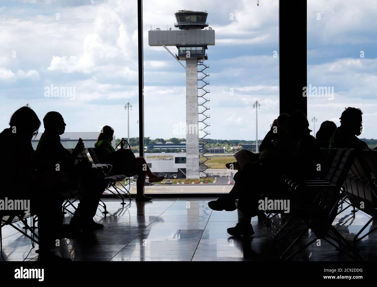 28 luglio 2020, Brandenburg, Schönefeld: Extra in giubbotti verdi ad alta visibilità aspettano l'imbarco durante la prova al Terminal 1 dell'aeroporto capitale Berlino-Brandeburgo (BER). Nella seconda fase del trasferimento operazionale e di aeroporto (ORAT), circa 500 - 600 dipendenti e 400 volontari hanno provato le procedure standard per i passeggeri, dal check-in al controllo di sicurezza fino all'imbarco e al deboarding (arrivo). Foto: Soeren Stache/dpa-Zentralbild/dpa Foto Stock