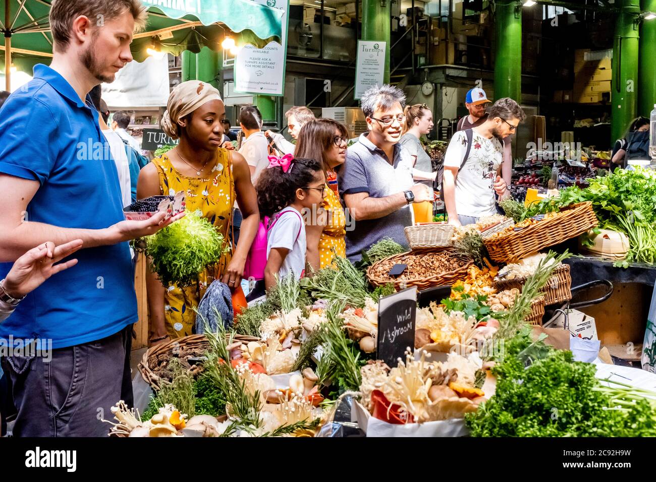 La gente acquista le verdure fresche da UNA stall in Borough Market, Londra, Inghilterra. Foto Stock