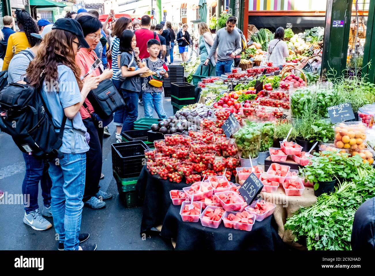 Persone asiatiche che acquistano frutta da UNA stall nel Borough Market, Londra, Inghilterra. Foto Stock
