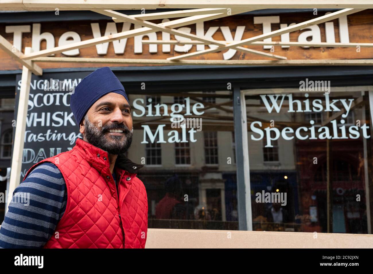 Edimburgo, Scozia, Regno Unito. 28 luglio 2020. Affari e turismo tornano lentamente ai negozi e alle strade del centro di Edimburgo. MR Bindi Landa fuori dal negozio Whisky Trail, in fase di ristrutturazione, sul Royal Mile, uno dei numerosi negozi di orientamento turistico che possiede. I suoi negozi sono in fase di riapertura per soddisfare un numero crescente di turisti che ritornano nella Città Vecchia. Iain Masterton/Alamy Live News Foto Stock