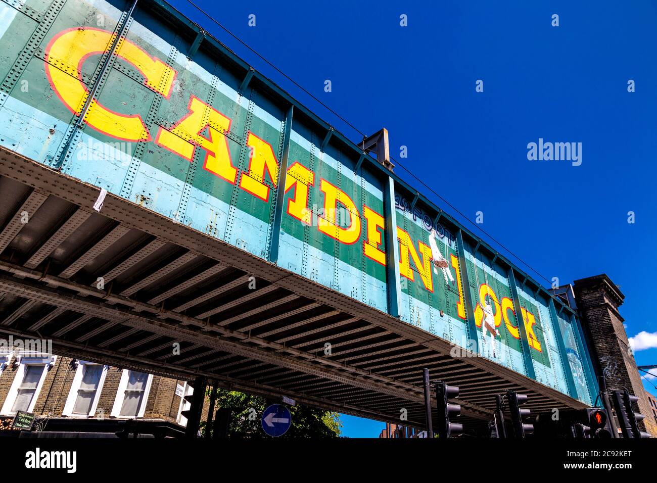 Il vecchio ponte della ferrovia su Chalk Farm Road a Camden Lock con un "trompe-l'oeil' immagine da artista John Bulley Foto Stock