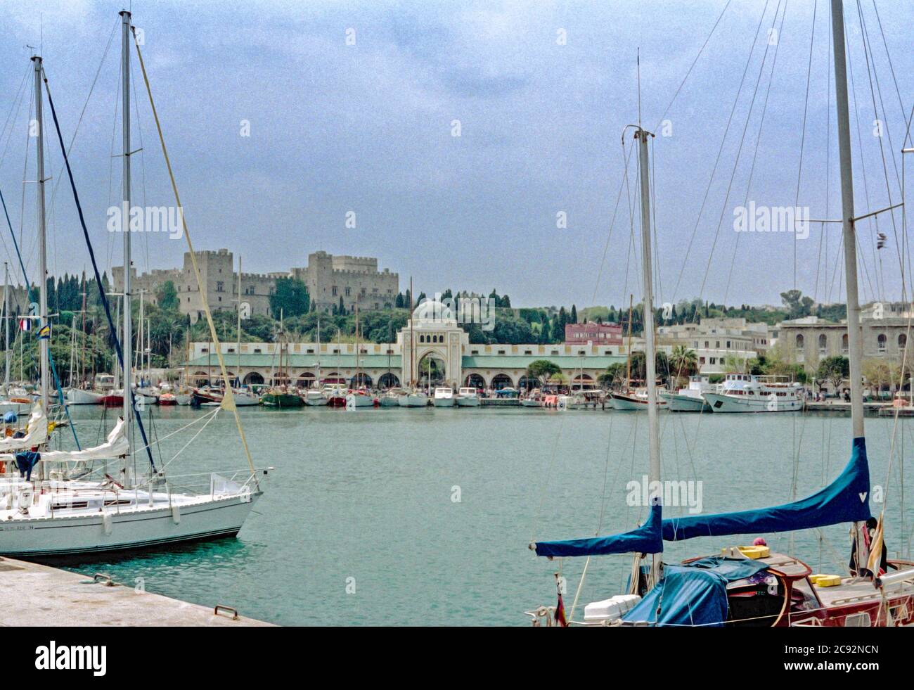 La storica banchina sul lungomare di Rodi con l'ingresso al mercato e il lontano palazzo di Rodi Grecia archivistico scannerizzato foto Foto Stock