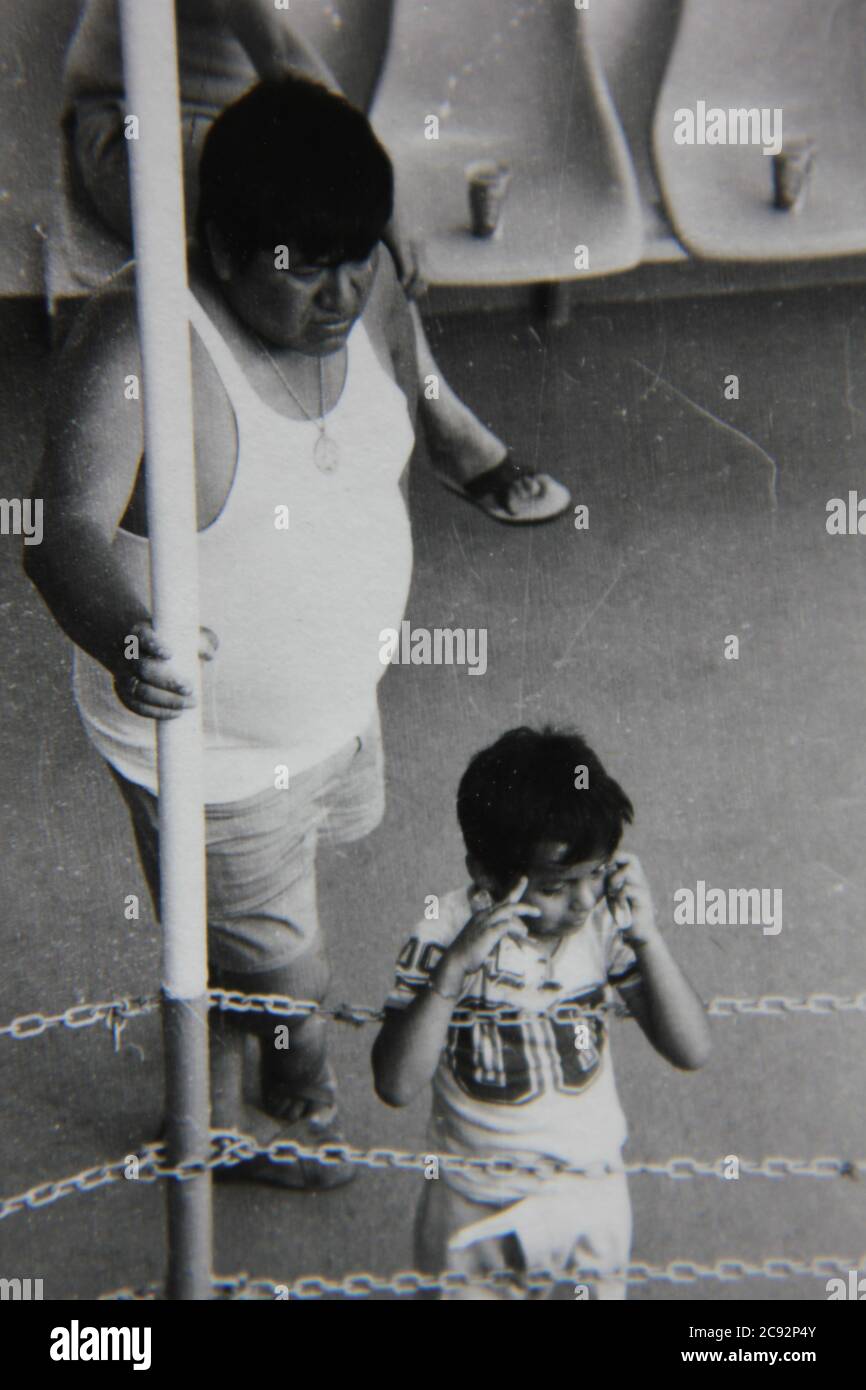 Bella fotografia in bianco e nero degli anni '70 di un padre che tende alla sua giovane figlia. Foto Stock