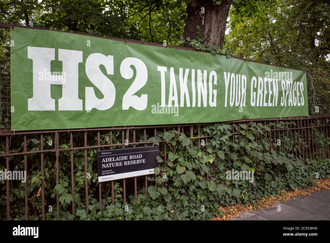 Striscione su una riserva naturale locale a Camden Town che si oppone all'HS2 (alta velocità 2) e al controverso impatto sull'habitat naturale. Foto Stock