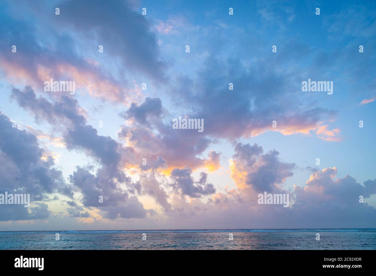 Belle nuvole rosa e arancio all'alba sul Mar dei Caraibi, Grand Cayman Island Foto Stock