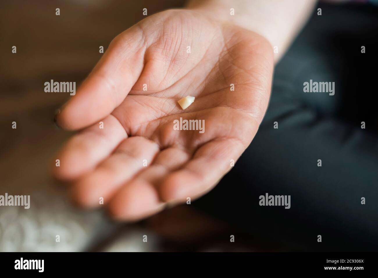 Primo piano della mano di un bambino che tiene un dente del bambino Foto Stock