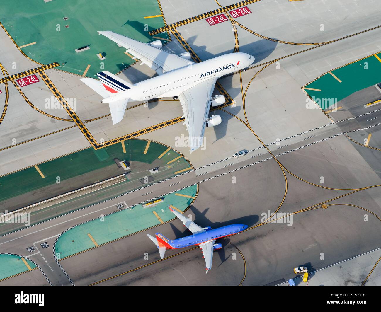 Confronto delle dimensioni della vista aerea degli aeromobili Airbus e Boeing. Enorme Air France Airbus A380 e piccolo Southwest Boeing 737 che tassano all'aeroporto di Los Angeles LAX. Foto Stock