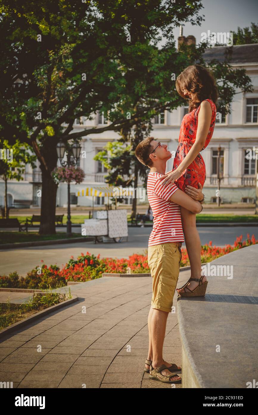 Bella coppia felice amorevole abbracciare e guardare l'un l'altro godendo del tempo insieme alla strada della città. Estate Foto Stock