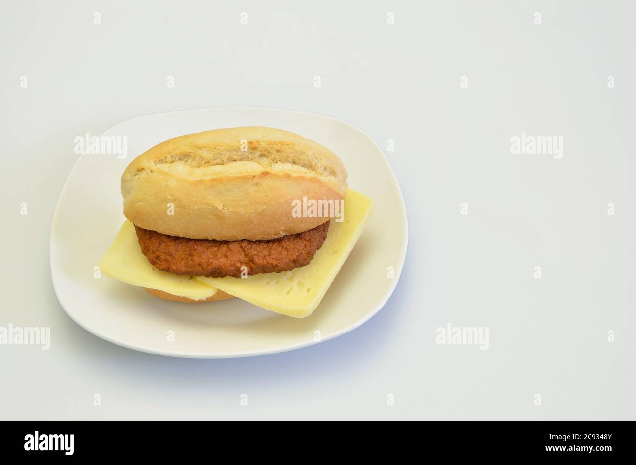 cheeseburger su piastra bianca, closeup, isolato su sfondo bianco Foto Stock