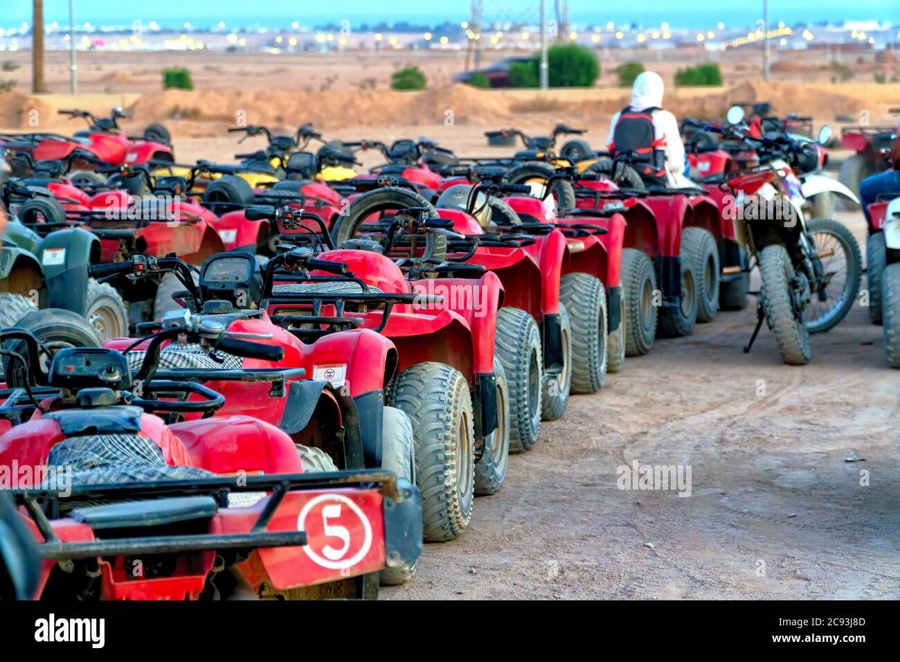 Una fila di veicoli rossi per tutti i terreni pronti per una nuova avventura nelle dune del deserto egiziano del Sahara Foto Stock