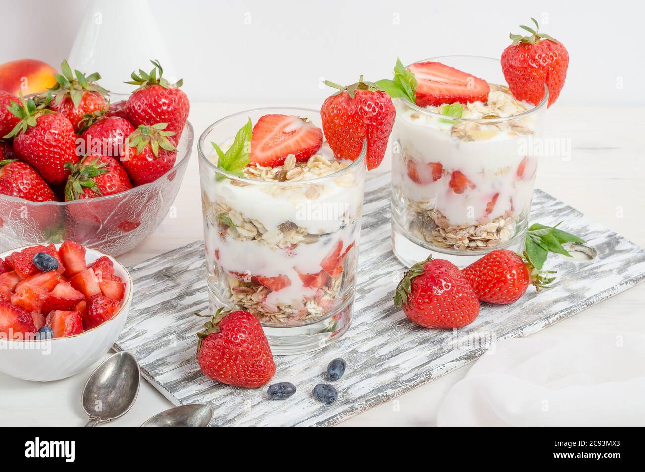 Muesli con yogurt e fragole fresche su fondo bianco. Foto Stock