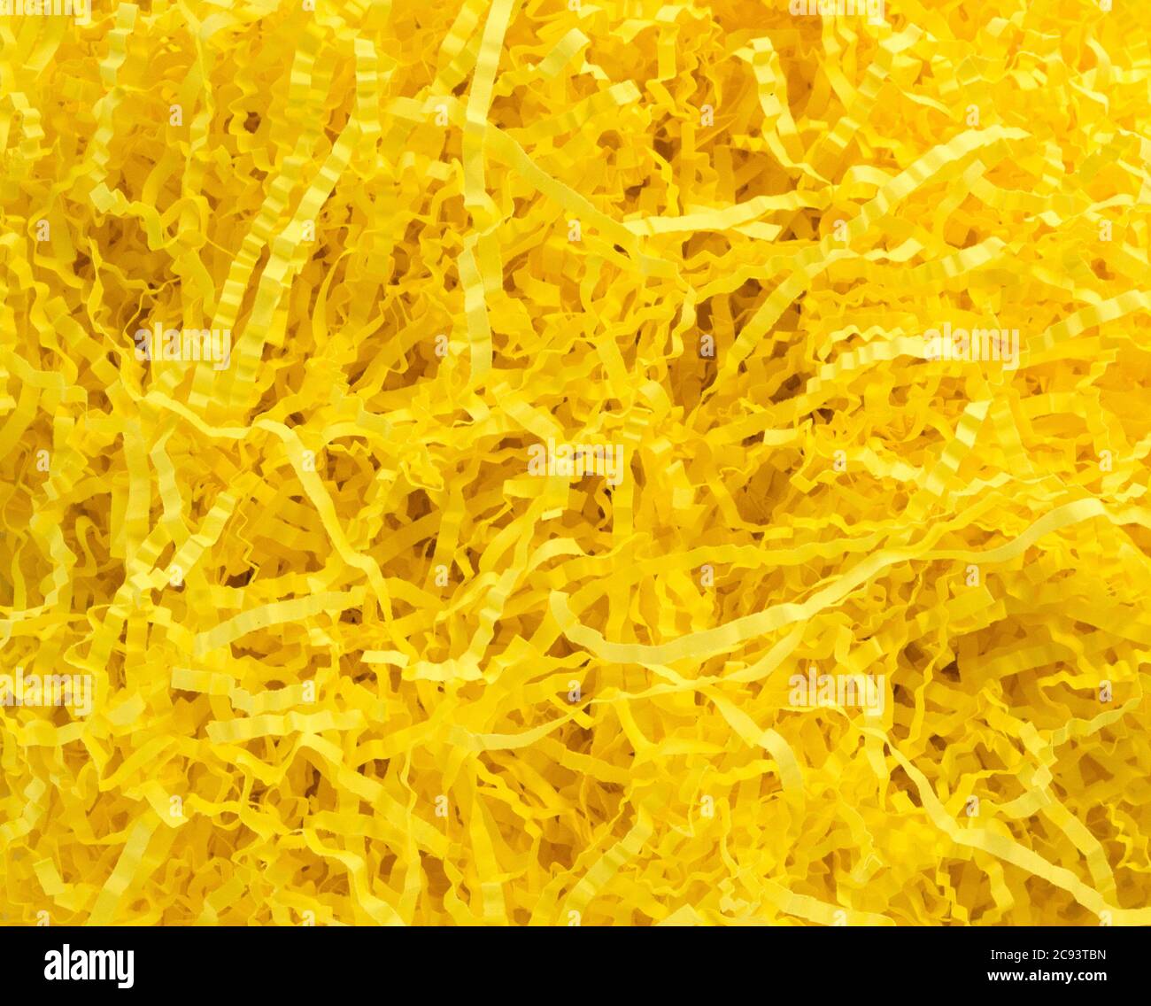 Texture di sfondo - un salto di giallo brillante cesto di Pasqua riempimento erba Foto Stock