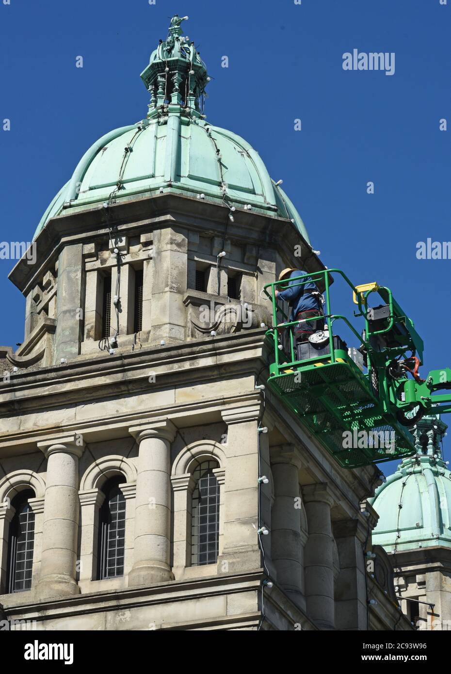 Victoria, British Columbia, Canada, 28, luglio 2020 - i lavoratori cambiano le lampadine e le corde di luce su una delle cupole dello storico edificio del Parlamento nel centro di Victoria. L'edificio ospita l'Assemblea legislativa della British Columbia che governa la provincia. Don Denton/Alamy Live News Foto Stock