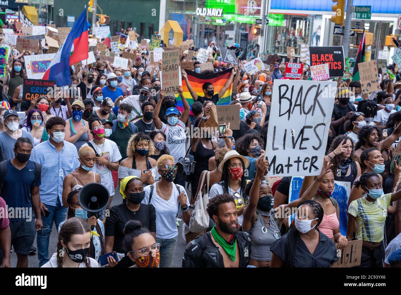 Black Womans/Womxn marzo protesta Black Lives Matter - folla di persone che marciano tenendo segni e bandiere BLM Foto Stock