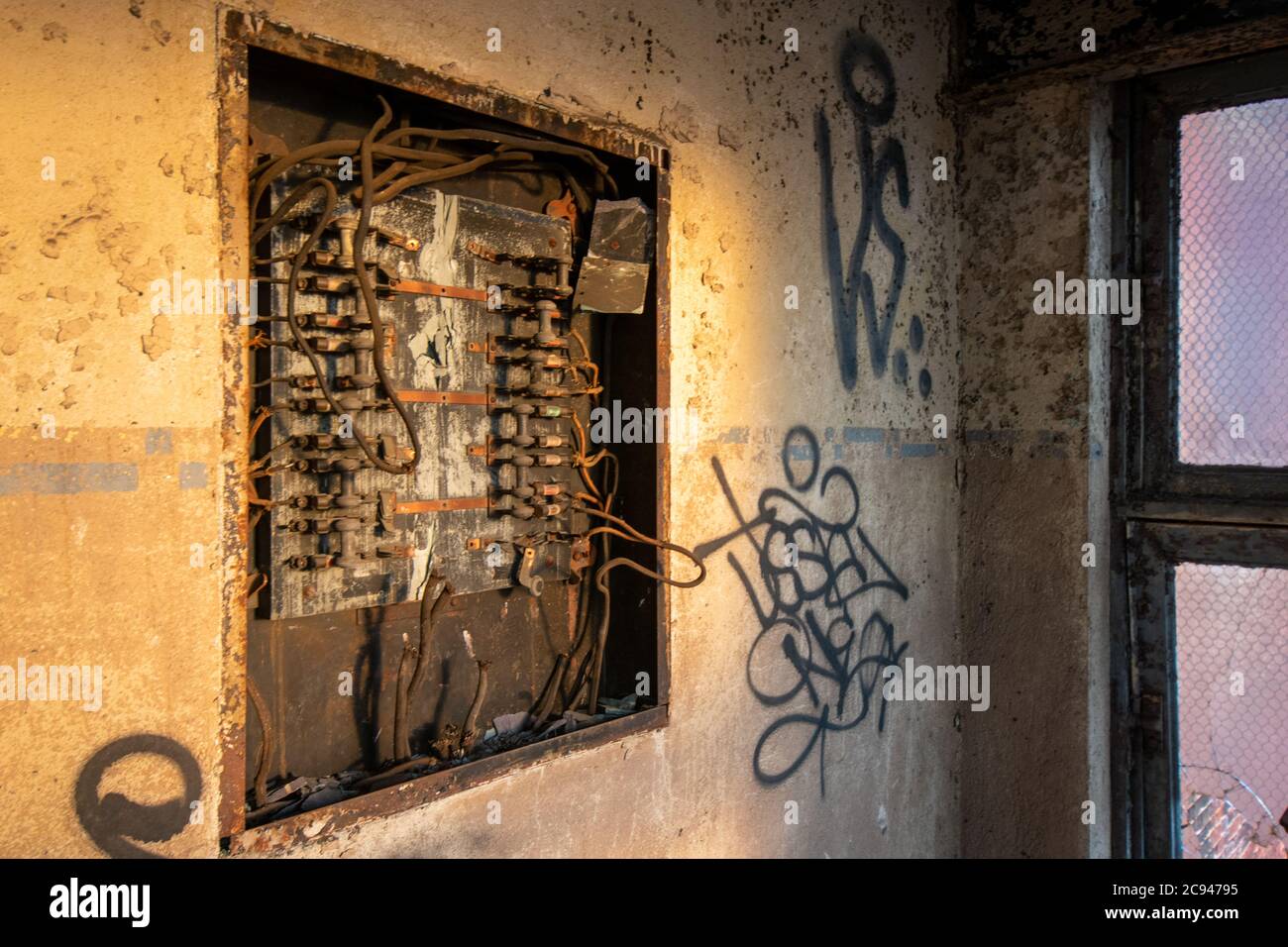 Un vecchio e arrugginito quadro elettrico in un edificio abbandonato Foto Stock