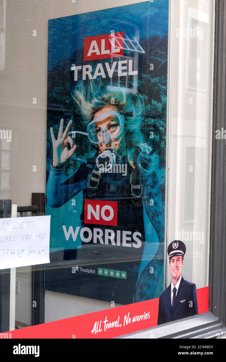Un poster che legge 'All Travel No preoccuparti' è visto nel negozio Flight Center a Covent Garden, Londra. Tutti i negozi Flight Center rimangono chiusi a causa della crisi del Covid-19 e con l'incertezza di ‘Air Bridges' come la Spagna che viene tirata, è un duro legame per gli agenti di viaggio. Foto Stock
