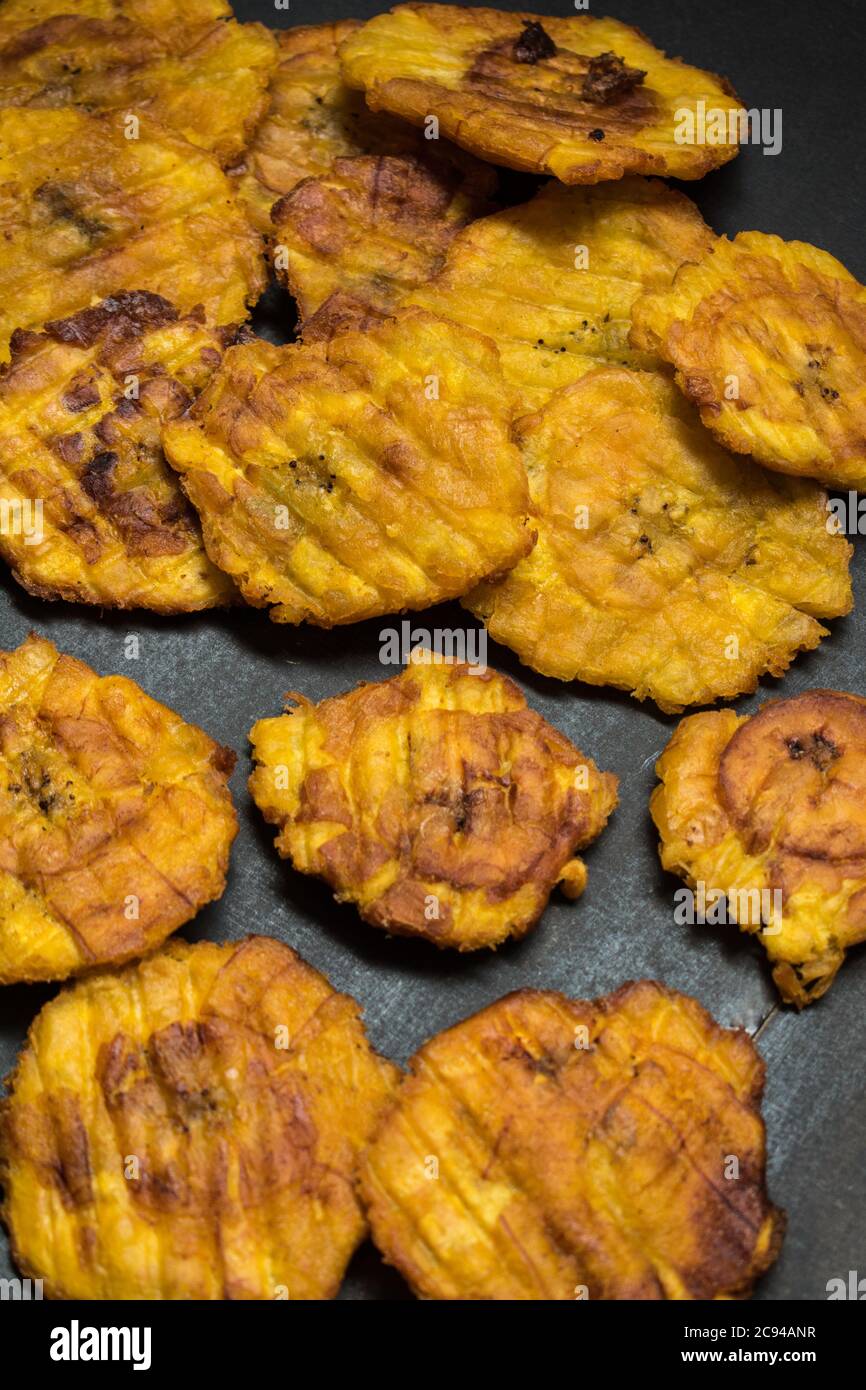 Tagliata gialla fritta banana latina su un tavolo nero Foto Stock
