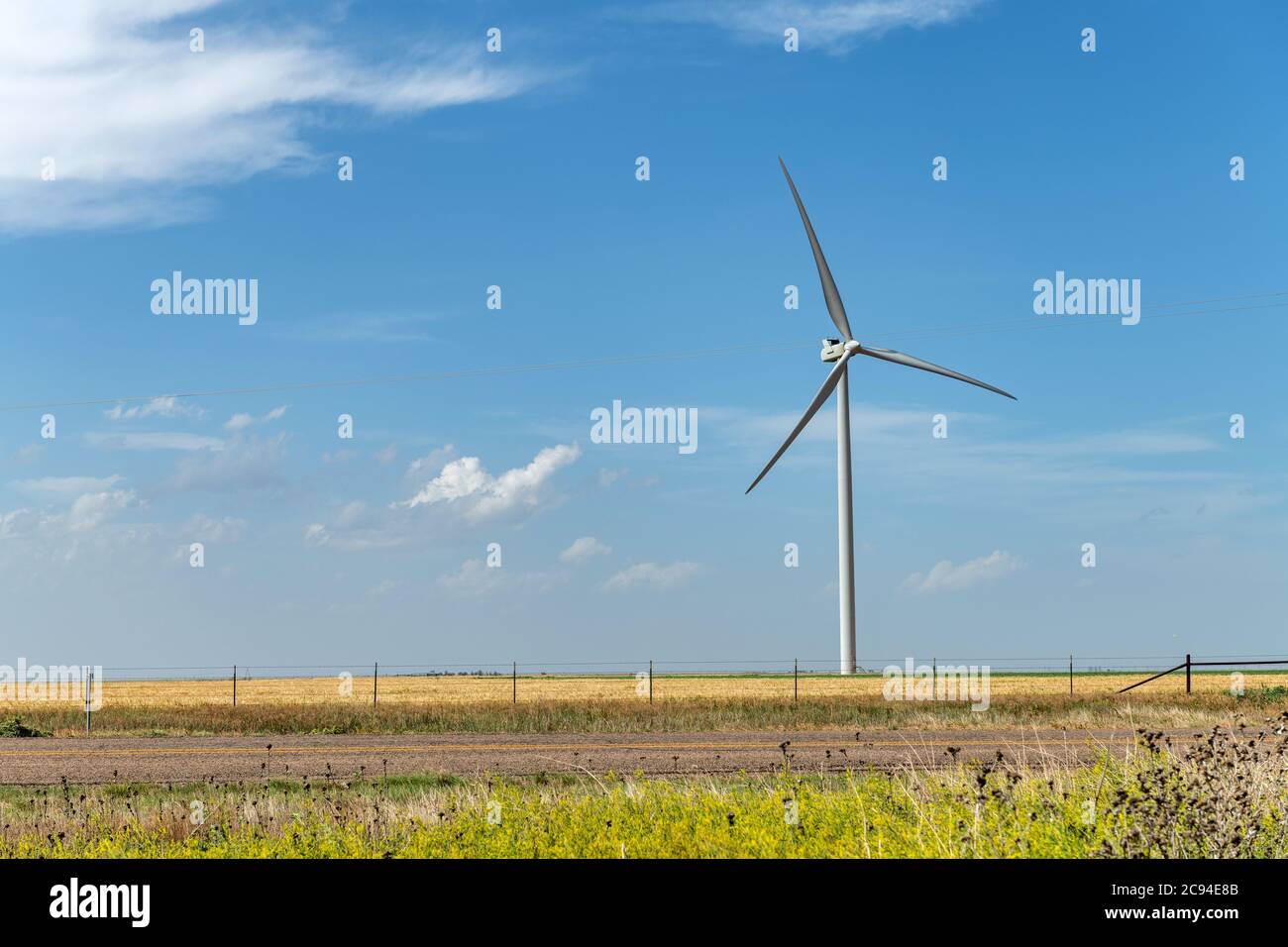 Un generatore di energia a turbina eolica solita si trova nel centro della zona rurale del Midwest durante il giorno luminoso. Foto Stock