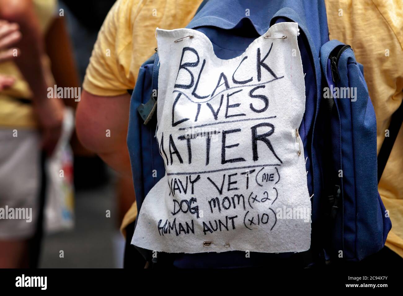 Mamma in giallo indossa un segno per sostenere la vita nera a Black Lives Matter Plaza a marzo contro lo Stato di polizia di Trump, Washington, DC, Stati Uniti Foto Stock