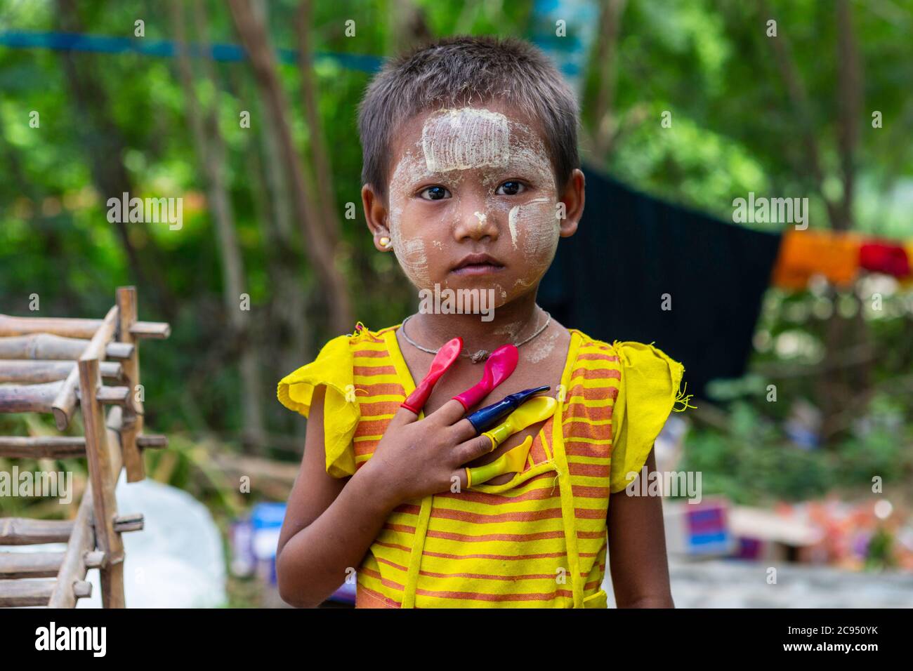 Sagaing/Myanmar-3 ottobre 2019: Una ragazza birmana indossa colori e dita appariscenti in palloncini di vari colori. Foto Stock