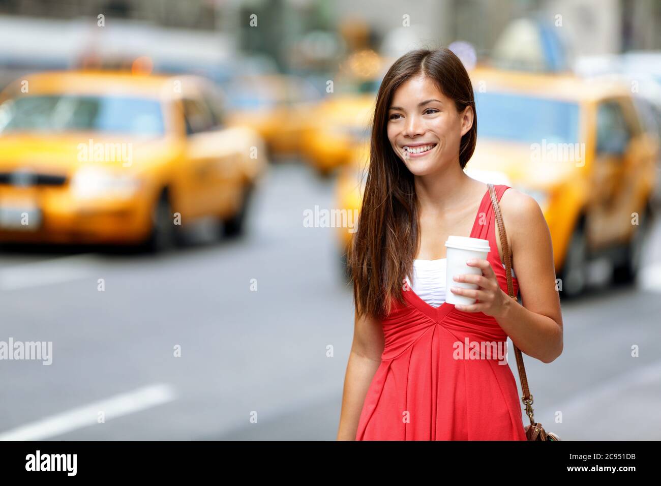 Happy Woman che tiene la tazza monouso su City Street Foto Stock