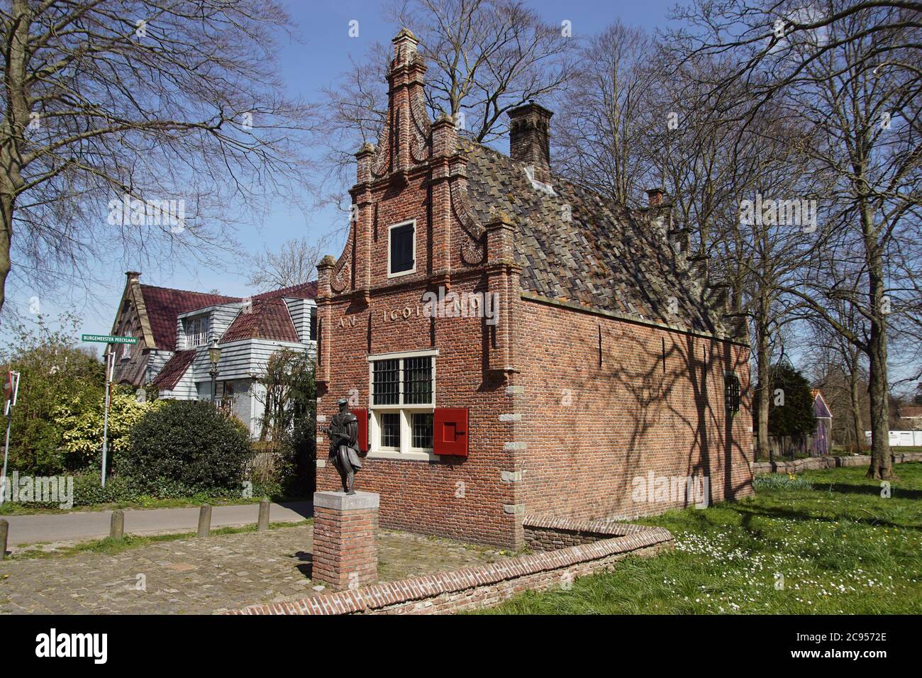 Bellissimo, piccolo, antico, antico municipio (1601) con di fronte una statua del pittore tardo medievale-olandese del Rinascimento Jan van Scorel. Aprile, Olanda Foto Stock