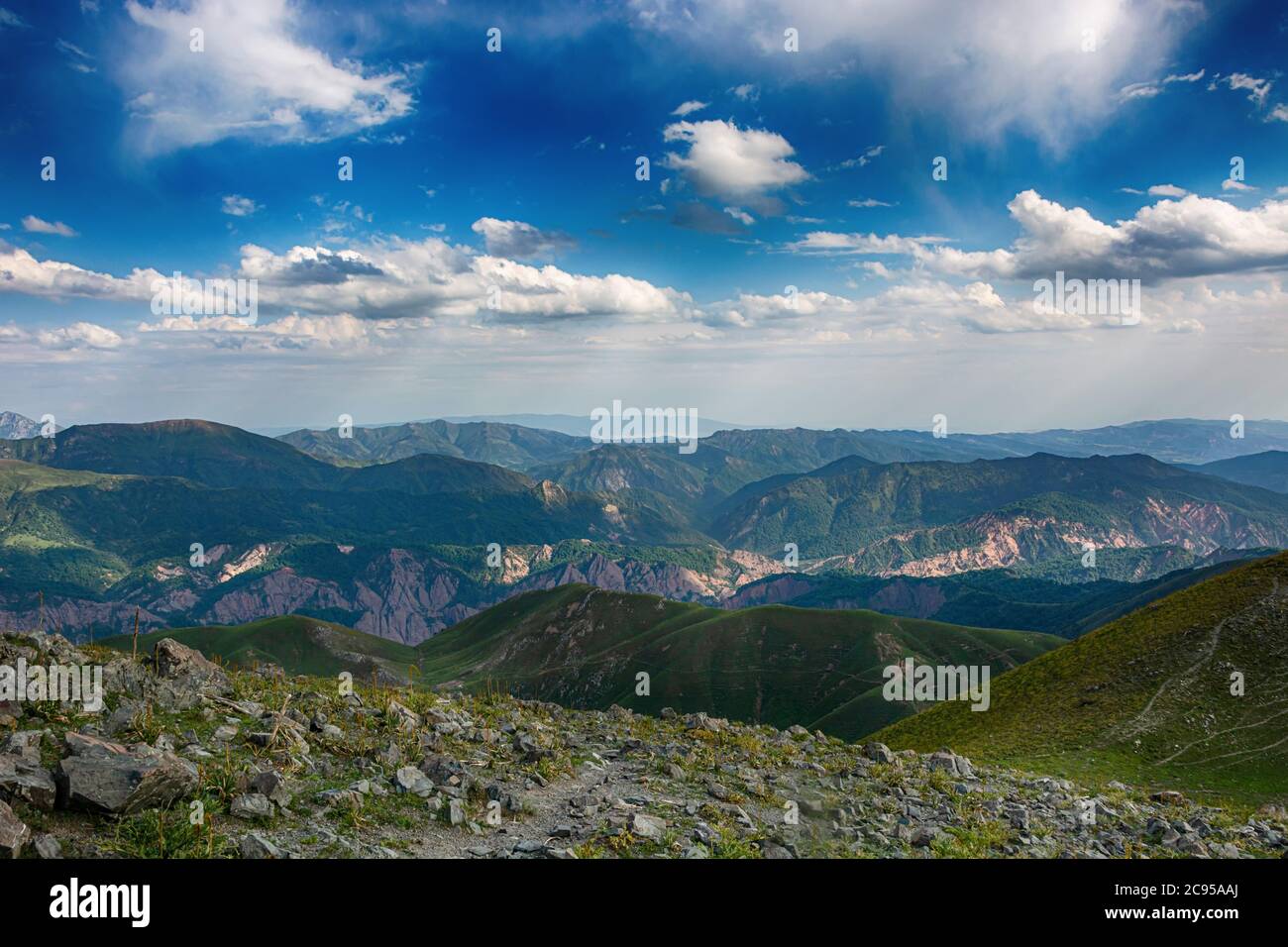 Idilliaco paesaggio estivo con sentieri escursionistici in montagna con bellissimi verdi pascoli di montagna, cielo blu e nuvole. Tian-Shan, Kirghizistan. Foto Stock