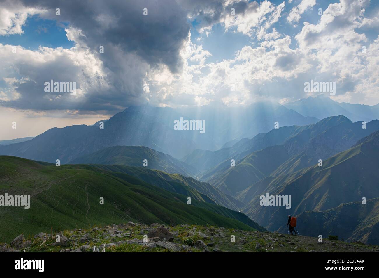 Idilliaco paesaggio estivo con sentieri escursionistici in montagna con bellissimi verdi pascoli di montagna, cielo blu e nuvole. Tian-Shan, Kirghizistan. Foto Stock