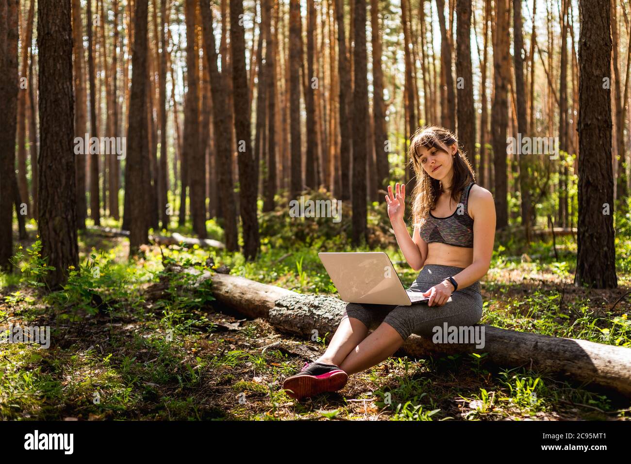 Comunicazione remota e lavoro in natura. Ragazza fa affari con le tecnologie in linea fuori. Il concetto di gadget elettronici per l'apprendimento a distanza Foto Stock