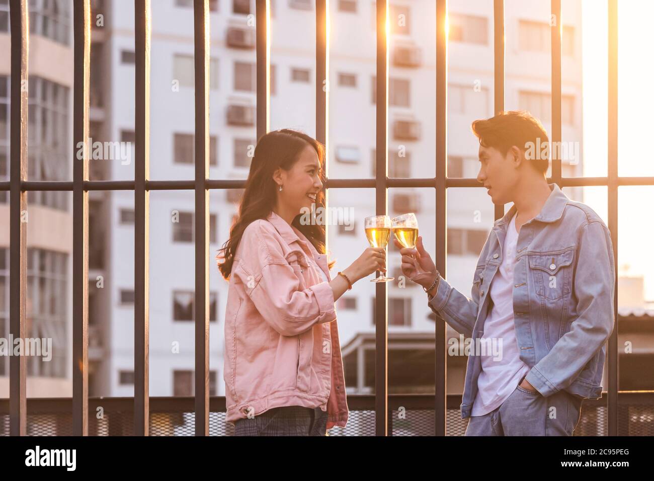 coppia amante asiatica uomo e donna che brinda e brinda con bicchieri da vino bianco a celebrare la prima datazione in festa a cena in estate. amore, celebrità Foto Stock