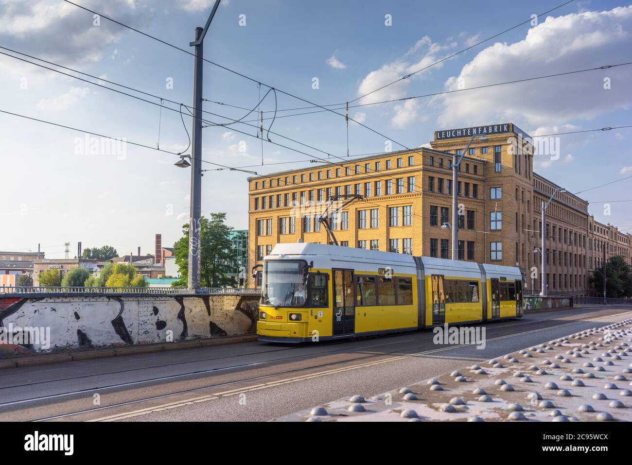 Un tram passava per Leuchtenfabrik, un vecchio edificio industriale lungo Edissonstrasse a Berlino Oberschöneweide, Berlino, Germania, Europa Foto Stock
