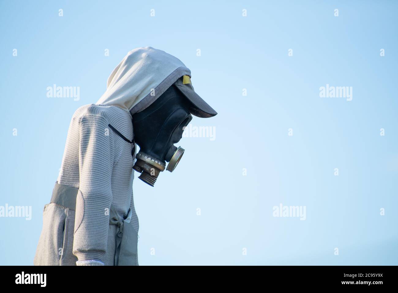 scarecrow con maschera a gas contro il cielo blu, simboleggiando il problema dell'inquinamento atmosferico, la diffusione globale del virus sul pianeta, la catastrofa chimica e l'apocalia Foto Stock