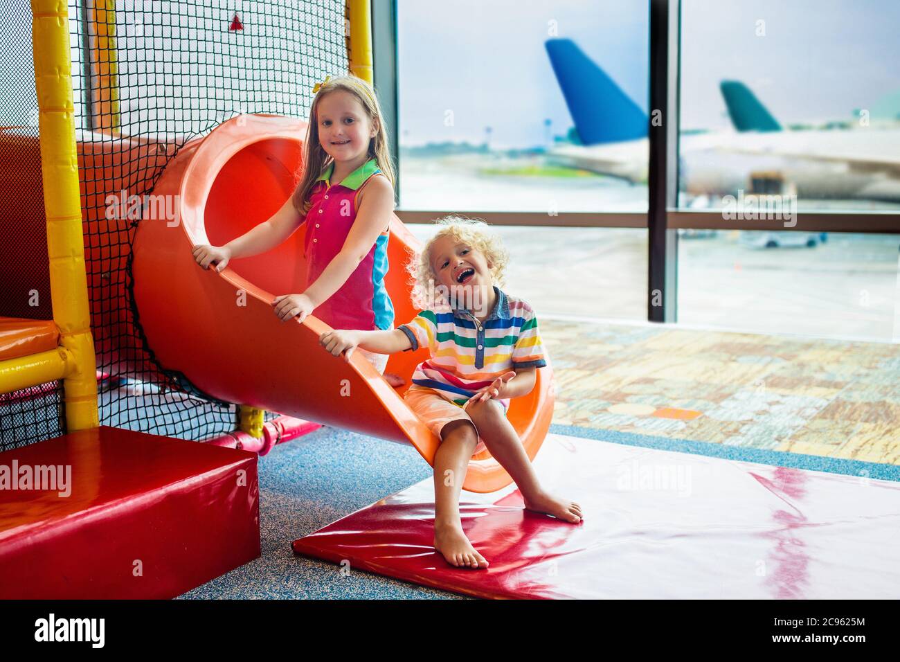 Bambini al parco giochi dell'aeroporto. I bambini guardano l'aereo.  Viaggiare e volare con il bambino. Famiglia al cancello di partenza.  Vacanza e viaggio con il bambino Foto stock - Alamy