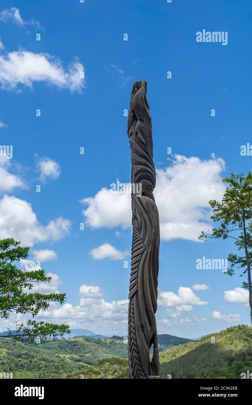 Enorme totem in legno tipico caledoniano nuovo. Parc des Grandes Fougères, Nuova Caledonia. Il cielo è blu Foto Stock