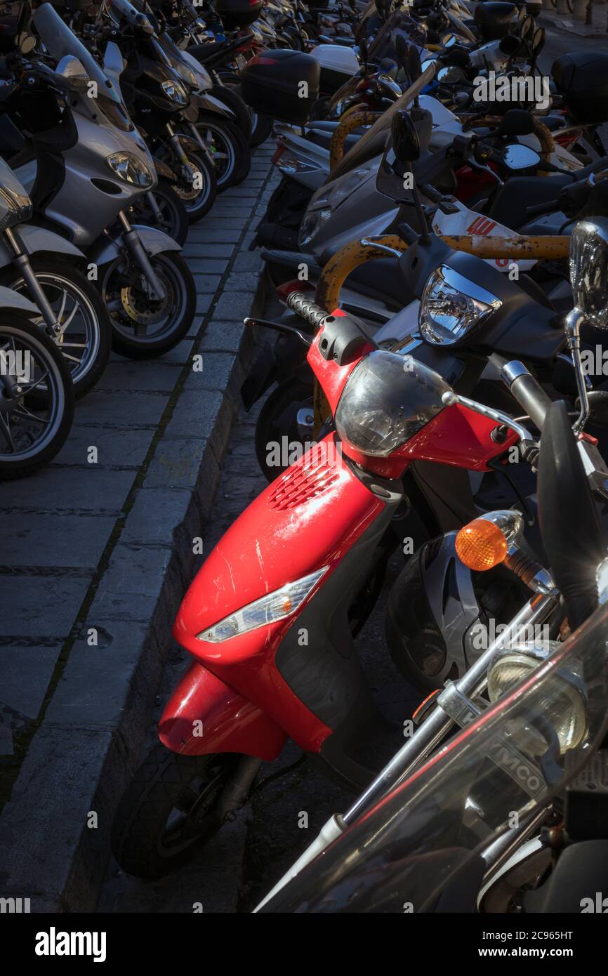 File di scooter a motore parcheggiati sulla strada della città. Foto Stock