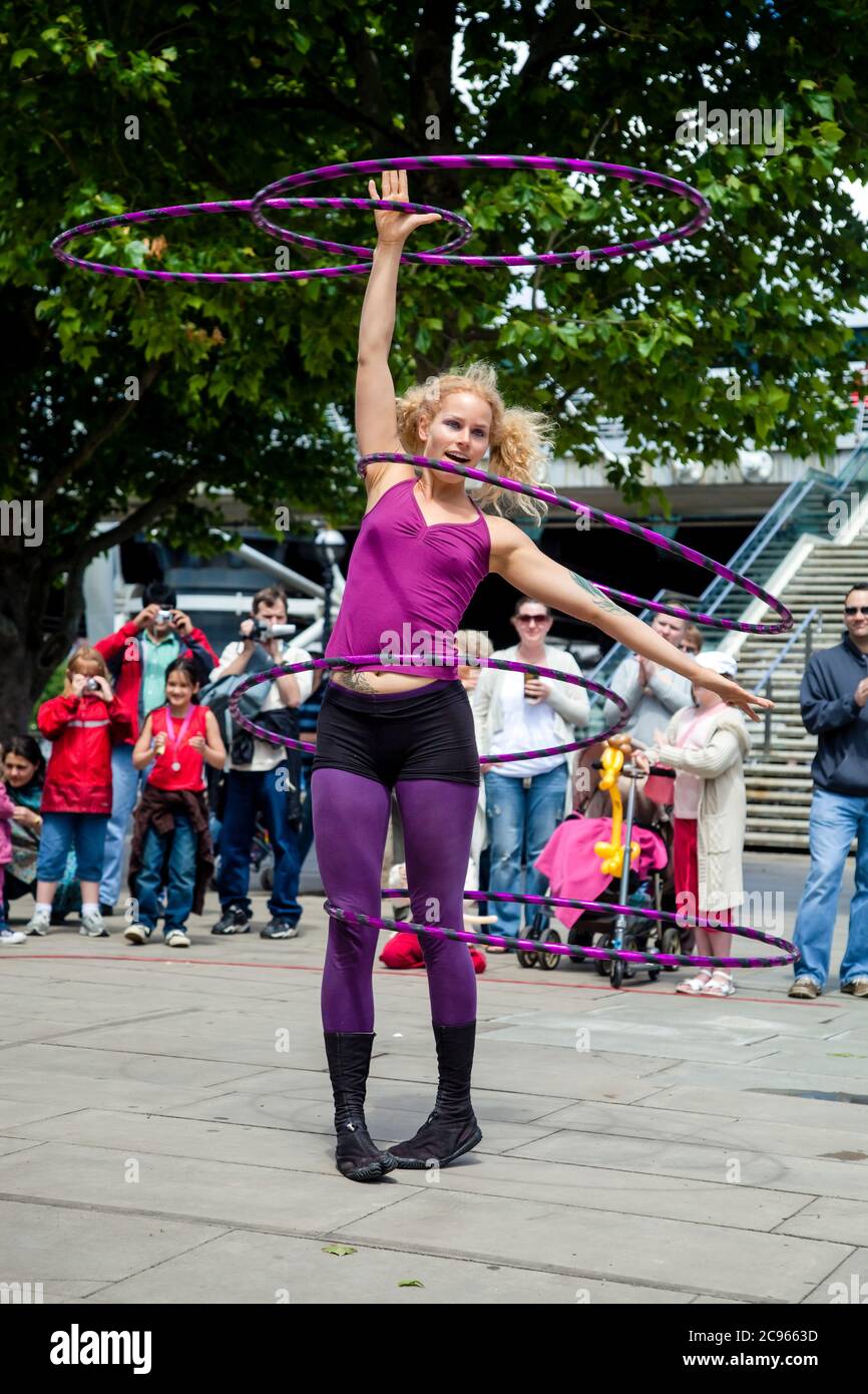 Londra, Gran Bretagna - UN artista di strada intrattiene i turisti sulla Thames Promenade con un acrobatico hula hoop atto. | Londra, Grossbritannien - Eine Foto Stock