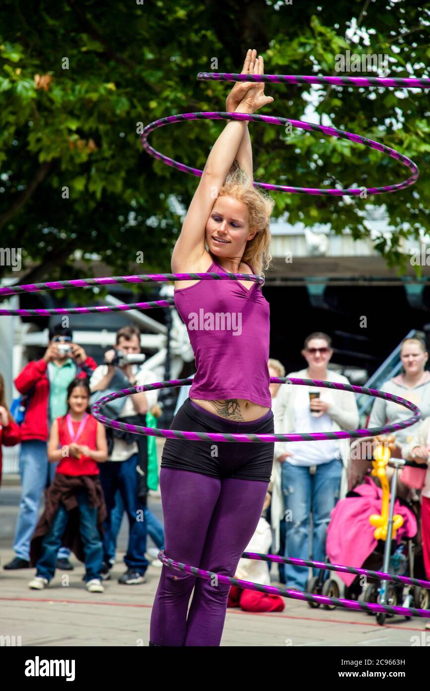 Londra, Gran Bretagna - UN artista di strada intrattiene i turisti sulla Thames Promenade con un acrobatico hula hoop atto. | Londra, Grossbritannien - Eine Foto Stock