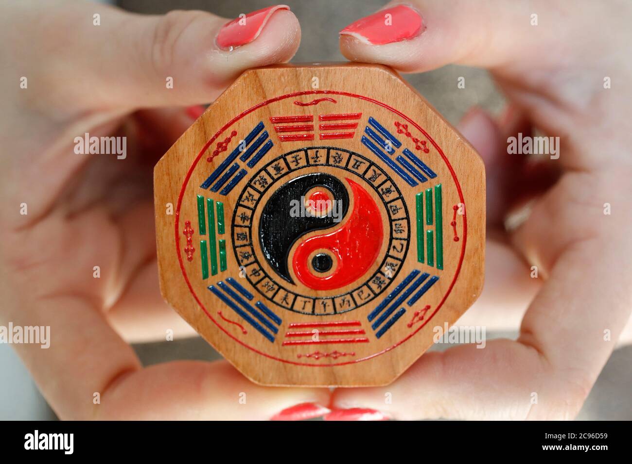 Donna con un cinese ba gua otto trigrammi lati ottagono yin yang simbolo. Ho Chi Minh City. Vietnam. Foto Stock