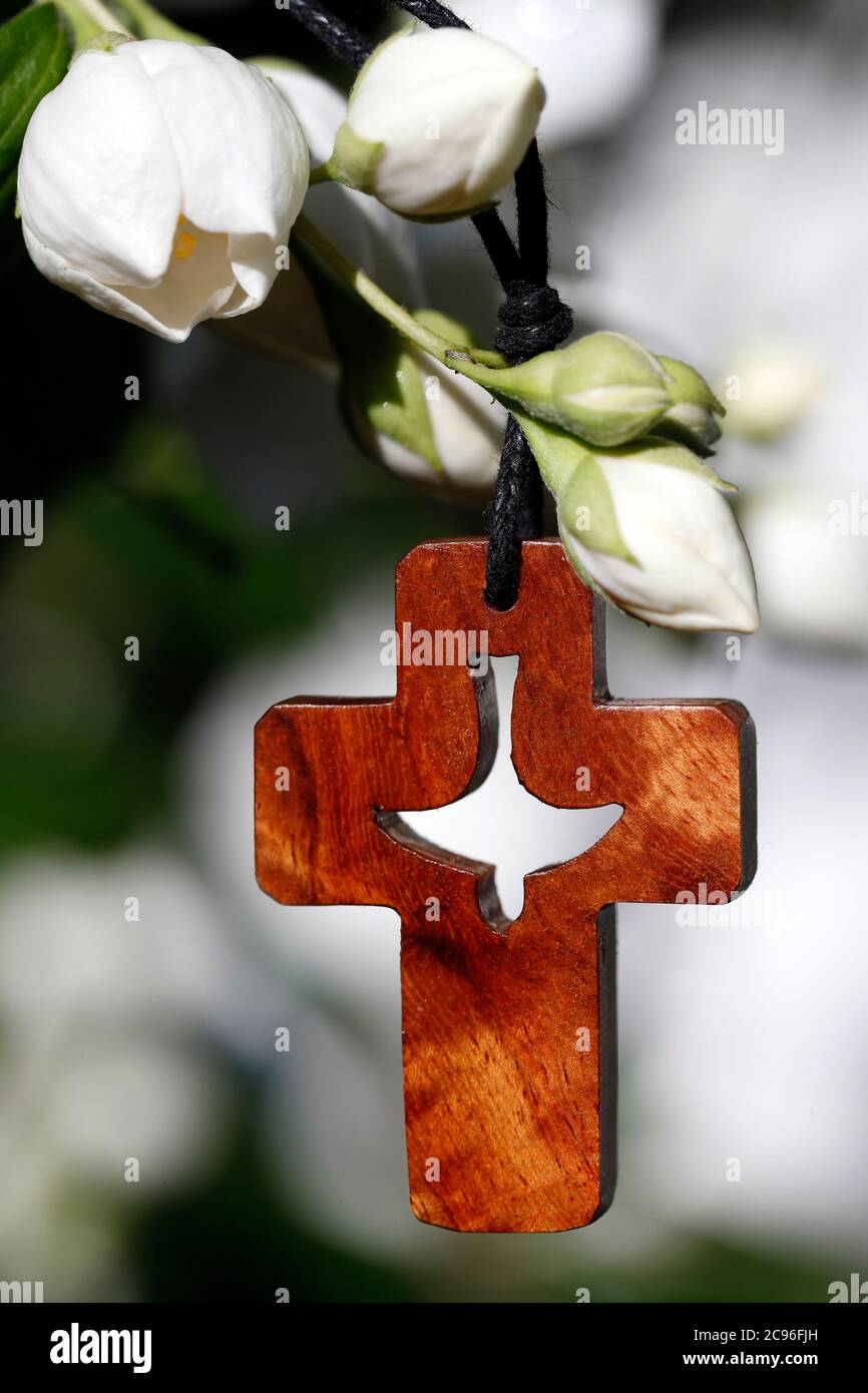 Croce cristiana con Spirito Santo e fiori bianchi. Francia. Foto Stock