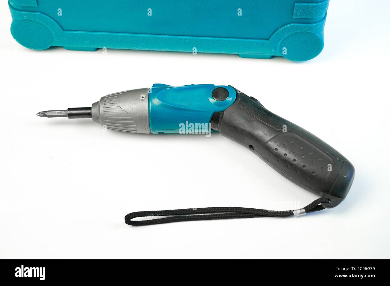 Il cacciavite elettrico si trova accanto al cassetto con un set di cacciaviti su sfondo bianco Foto Stock