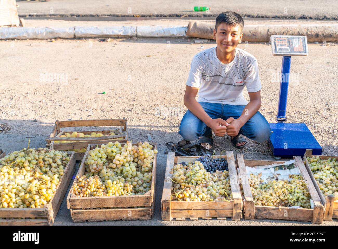 Khujand/Tagikistan-05.18.2020: Il ragazzo yong che vende uva sul tradizionale bazar tagikistan Foto Stock