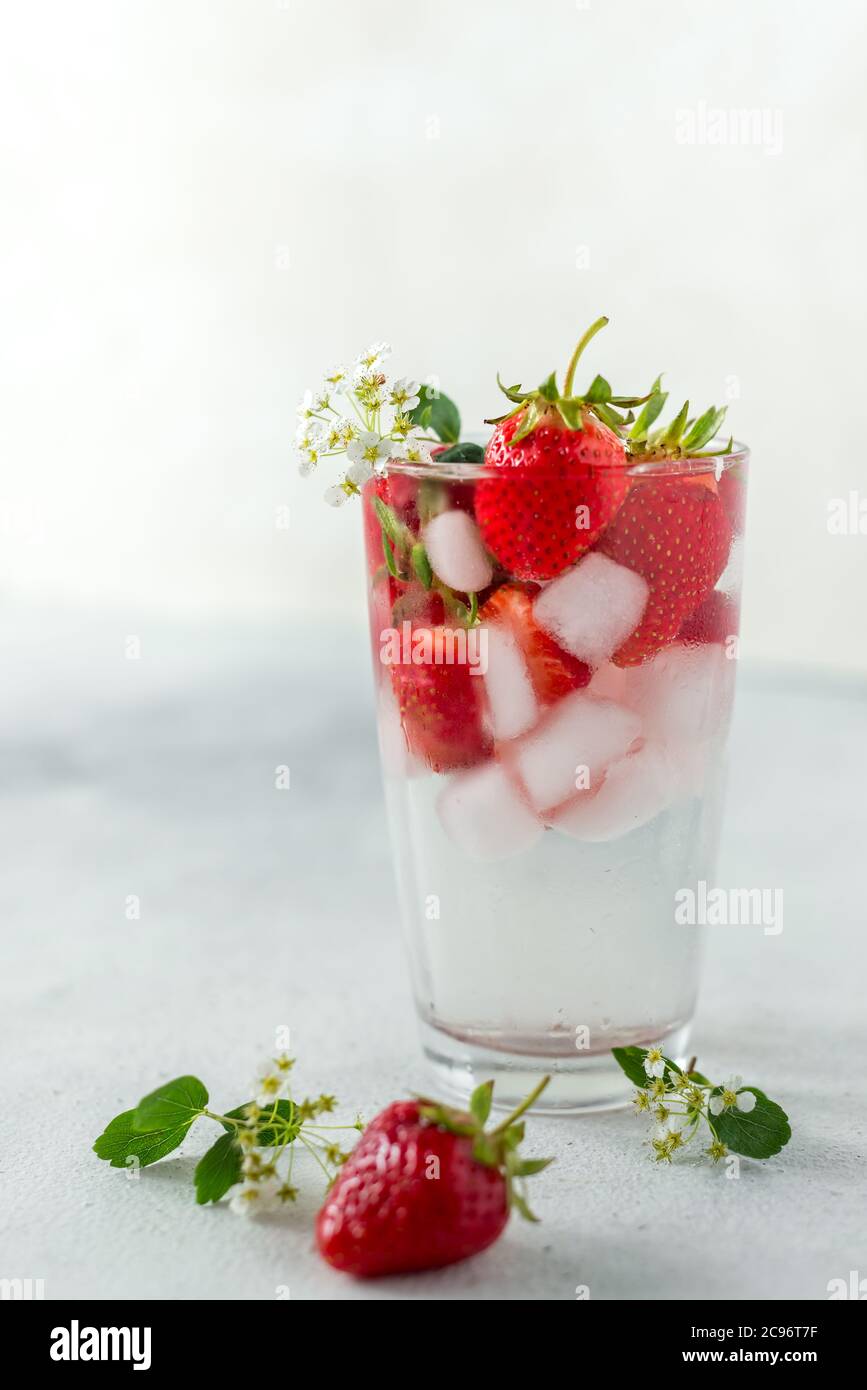 bicchiere con una bevanda gassata fresca estiva, ghiaccio e fragole. Freschezza rinfrescante Foto Stock