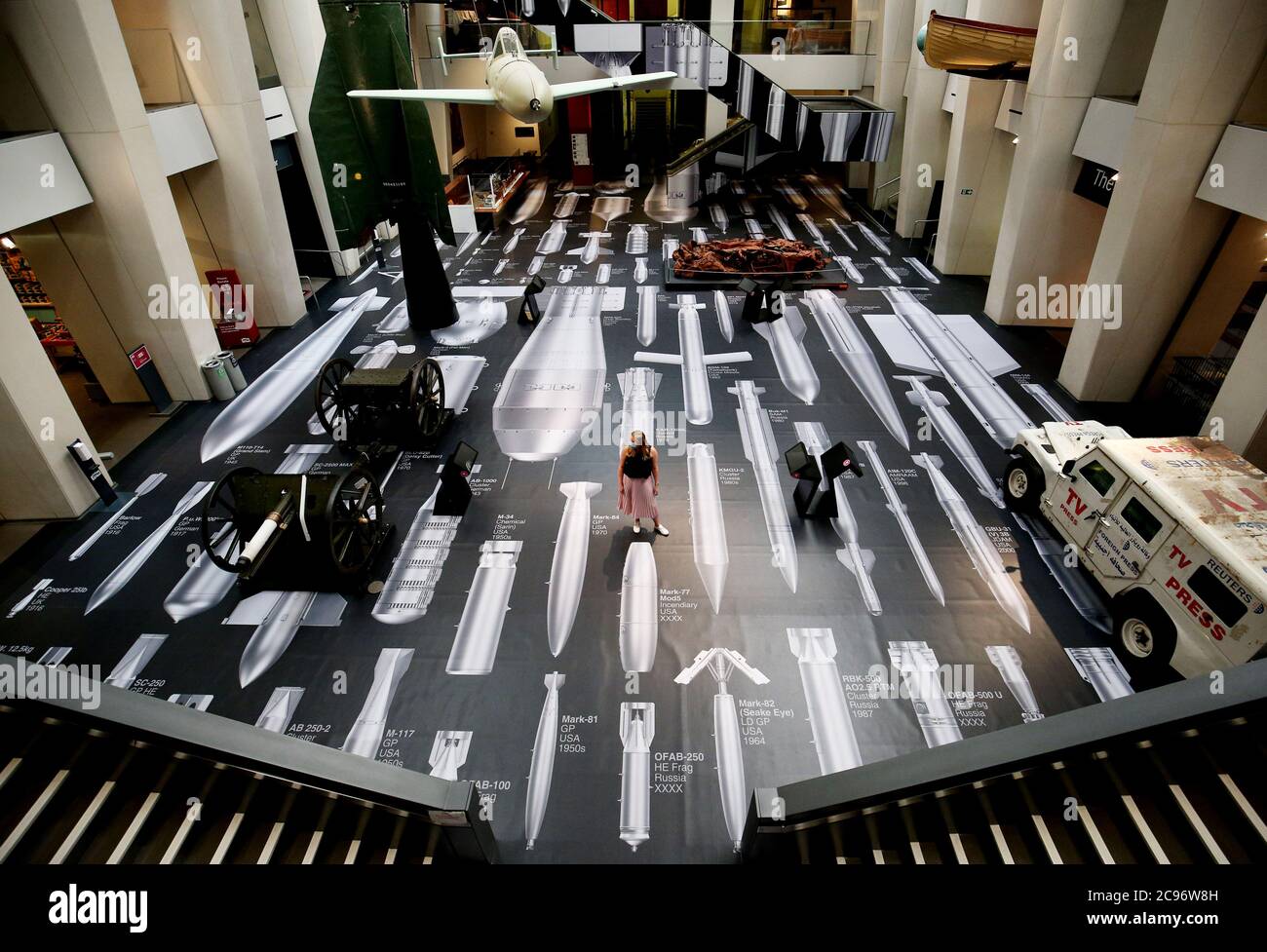 Un membro del personale dell'Imperial War Museum si trova su una parte della superficie della "Storia delle bombe" di ai Weiwei durante una fotocellula per la nuova opera dell'artista cinese in mostra all'Imperial War Museum di Londra. Con 50 bombe in scala, dalla prima guerra mondiale ai giorni nostri, l'opera d'arte copre i pavimenti e le pareti dell'atrio dell'IWM, che si estende per oltre 1,000 metri quadrati. Foto Stock